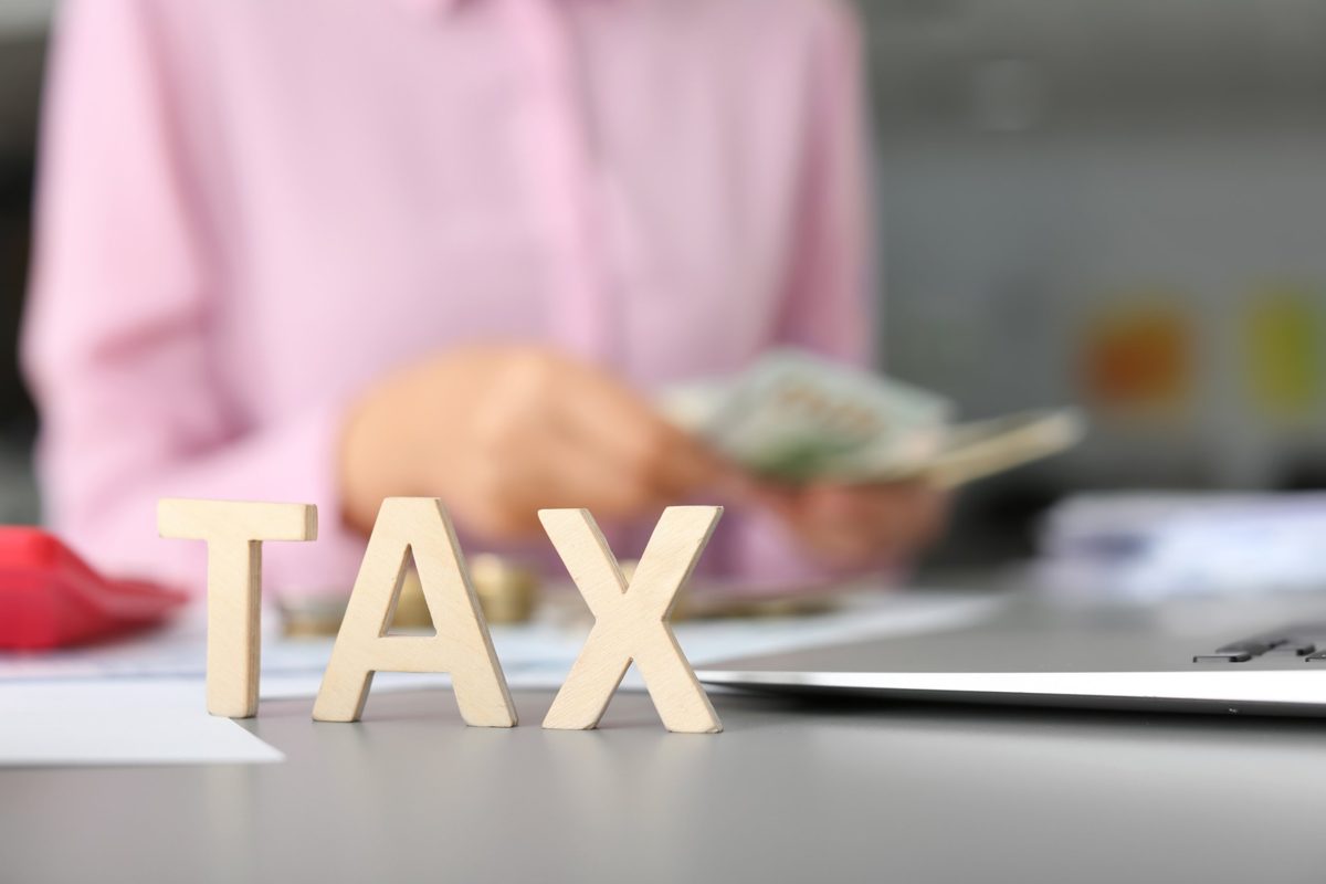 Wooden letters spelling TAX on a desk