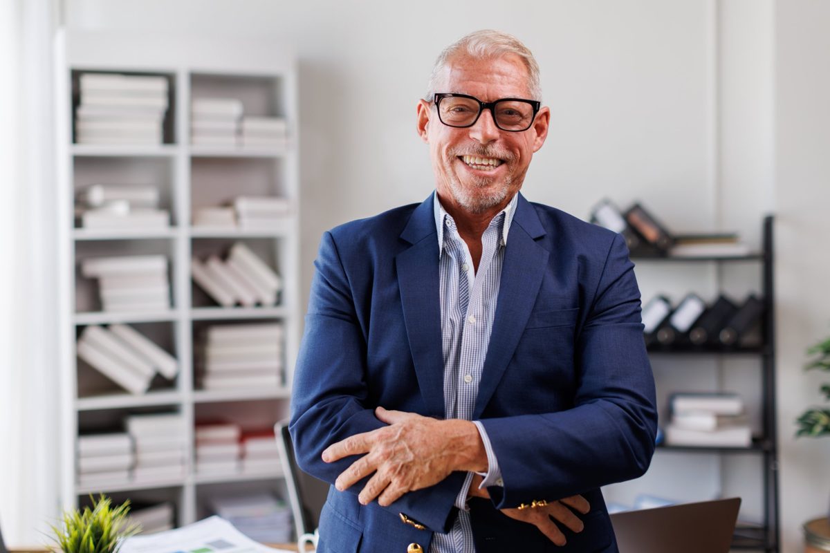 A smiling professional in an office with files and binders